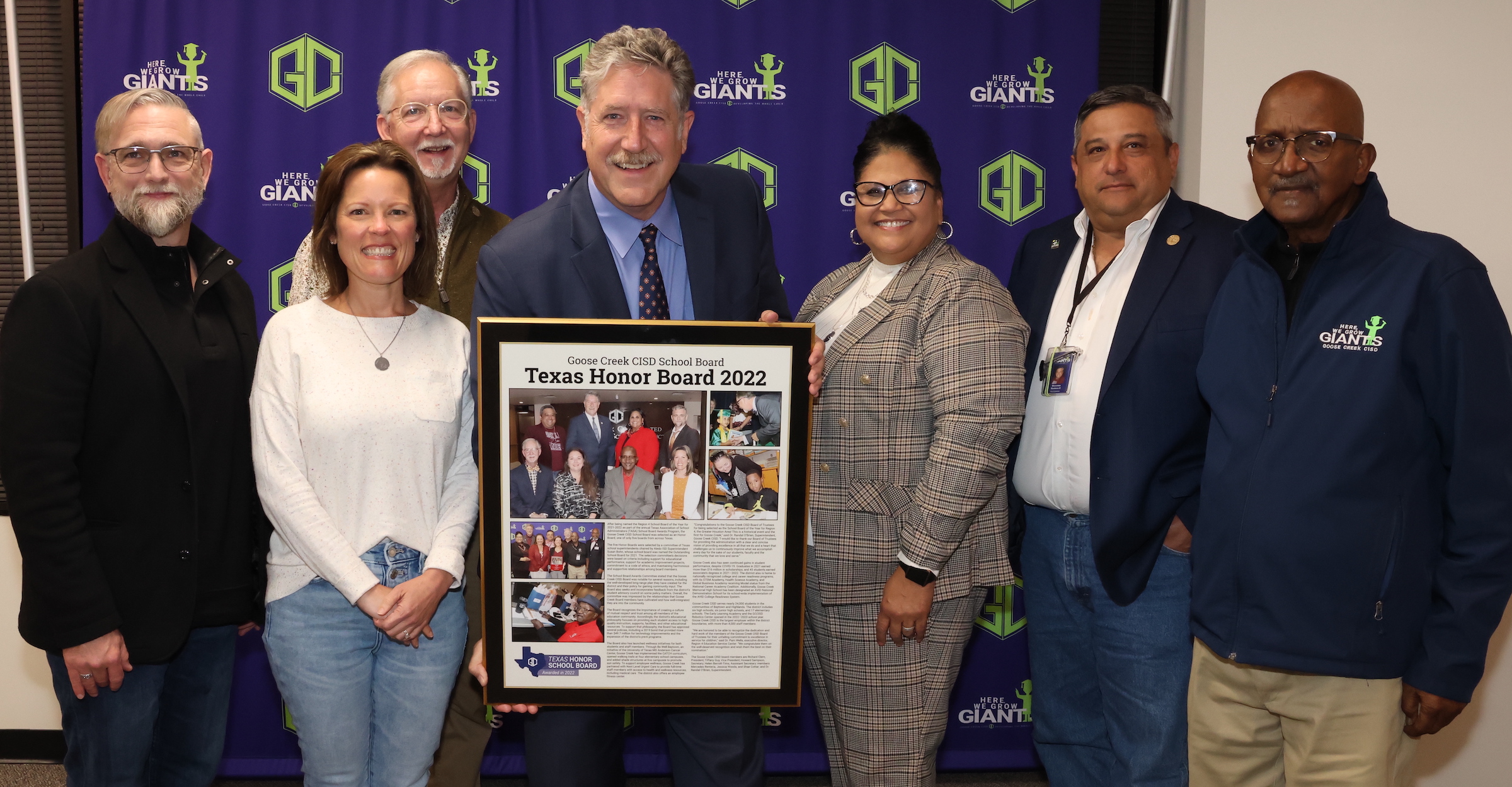 school board and superintendent pose with a plaque in honor of the board being named honor board